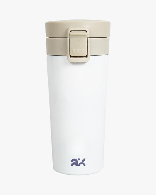 White travel mug with beige lid on a white background