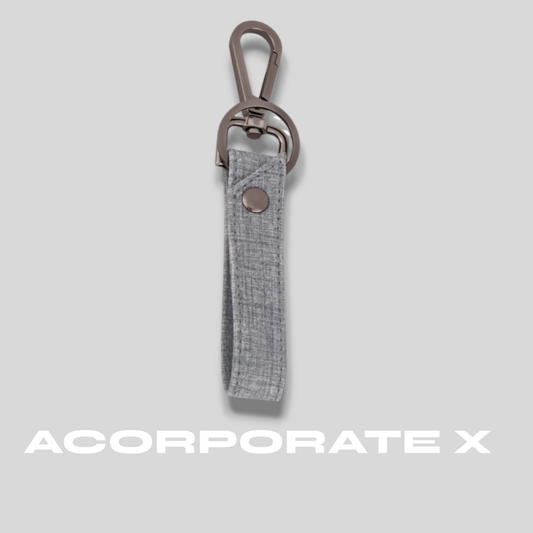 Gray keychain with a clip on a light gray background, featuring the brand 'ACorporate X'.
